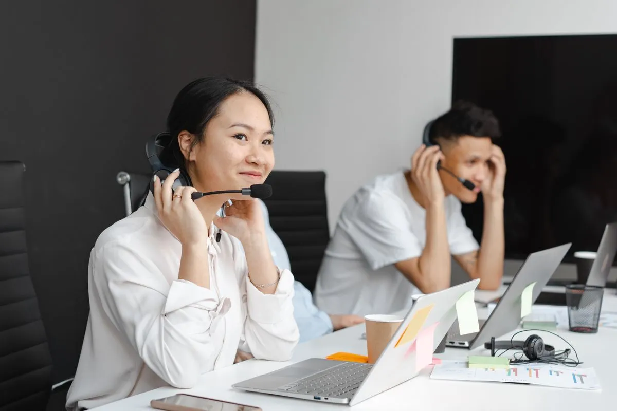 Customer support agents wearing headsets at a shared desk